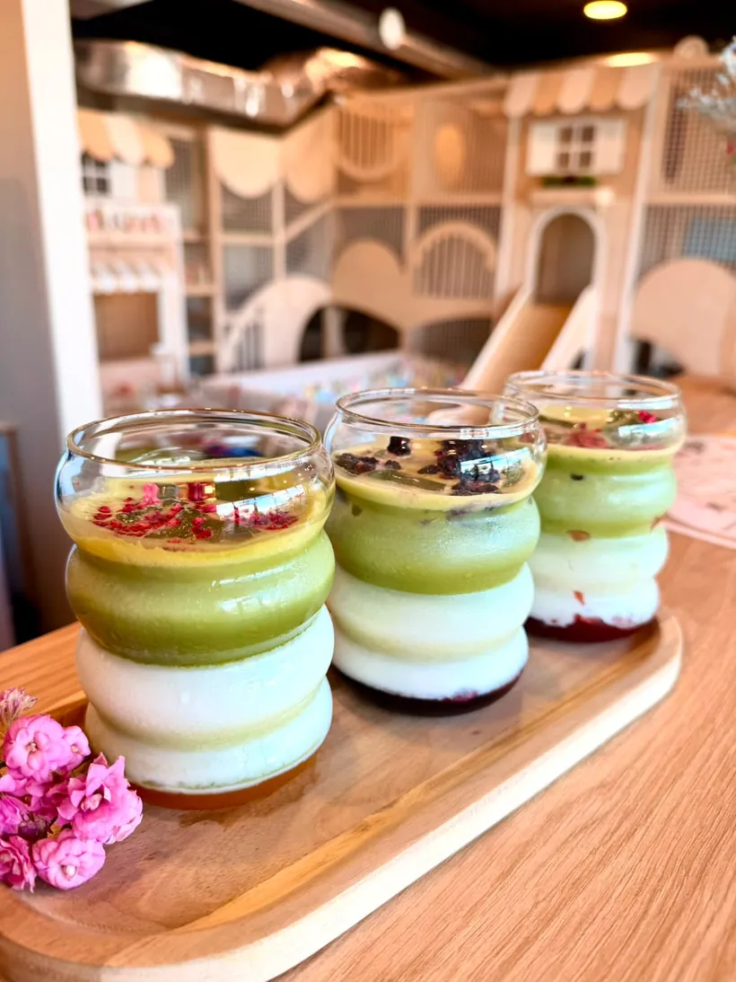 Trzy deserki matcha w szklanych słoiczkach na desce