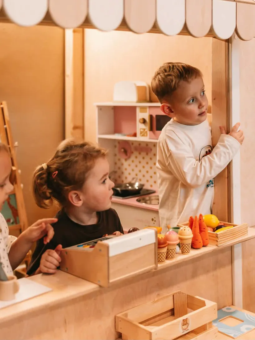 Dzieci w drewnianym domku z tablicą do rysowania