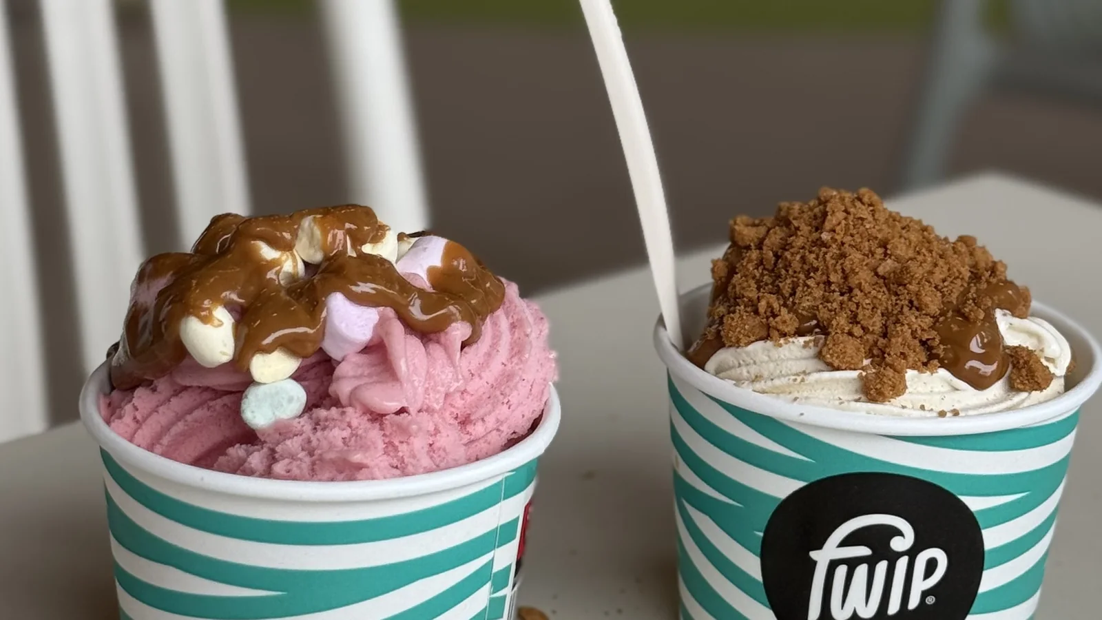 Dwa lody fwip w kubeczkach na stoliku, w tle strefa zabawy