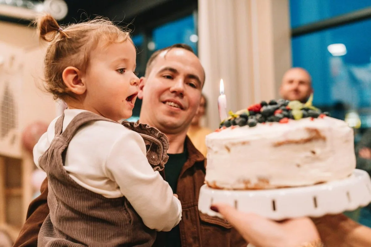 Tort urodzinowy podawany dziecku w bawialni